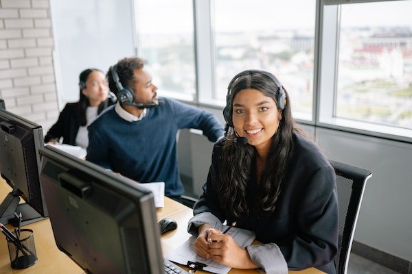 per avviare il tuo business devi chiederti cosa puoi fare per gli altri. nella foto una ragazza al lavoro al computer con cuffie e microfono