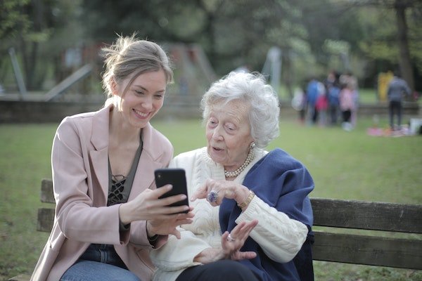 il coraggio si dimostra anche aiutando gli altri, nella foto due donne di diversa età, una più giovane e l'altra più anziana, utilizzano assieme uno smartphone